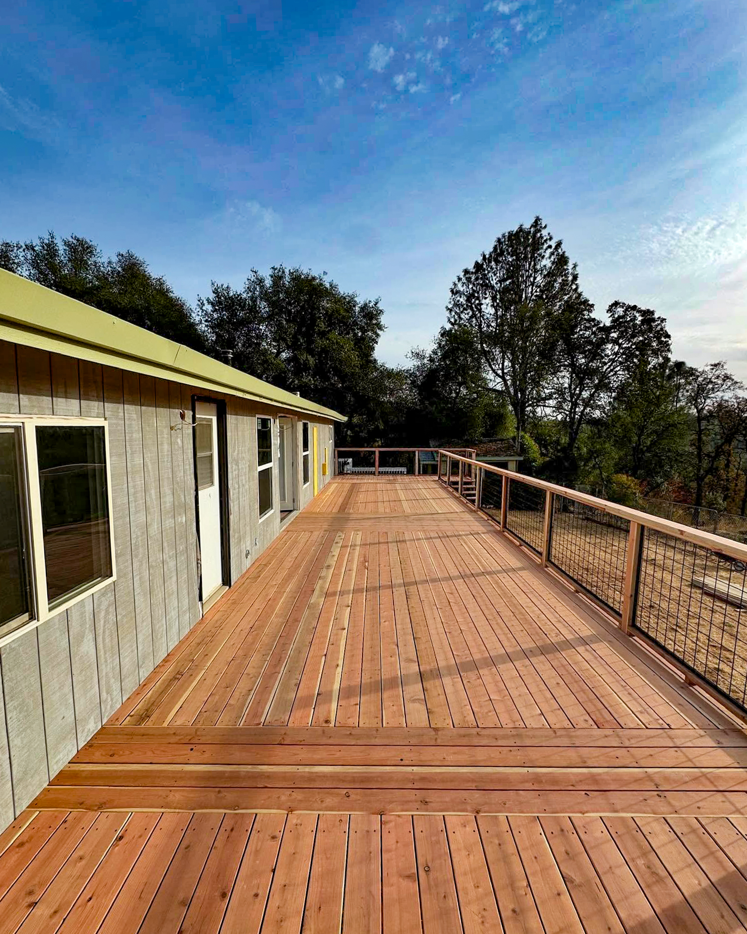 Long natural wood deck adjacent to structure