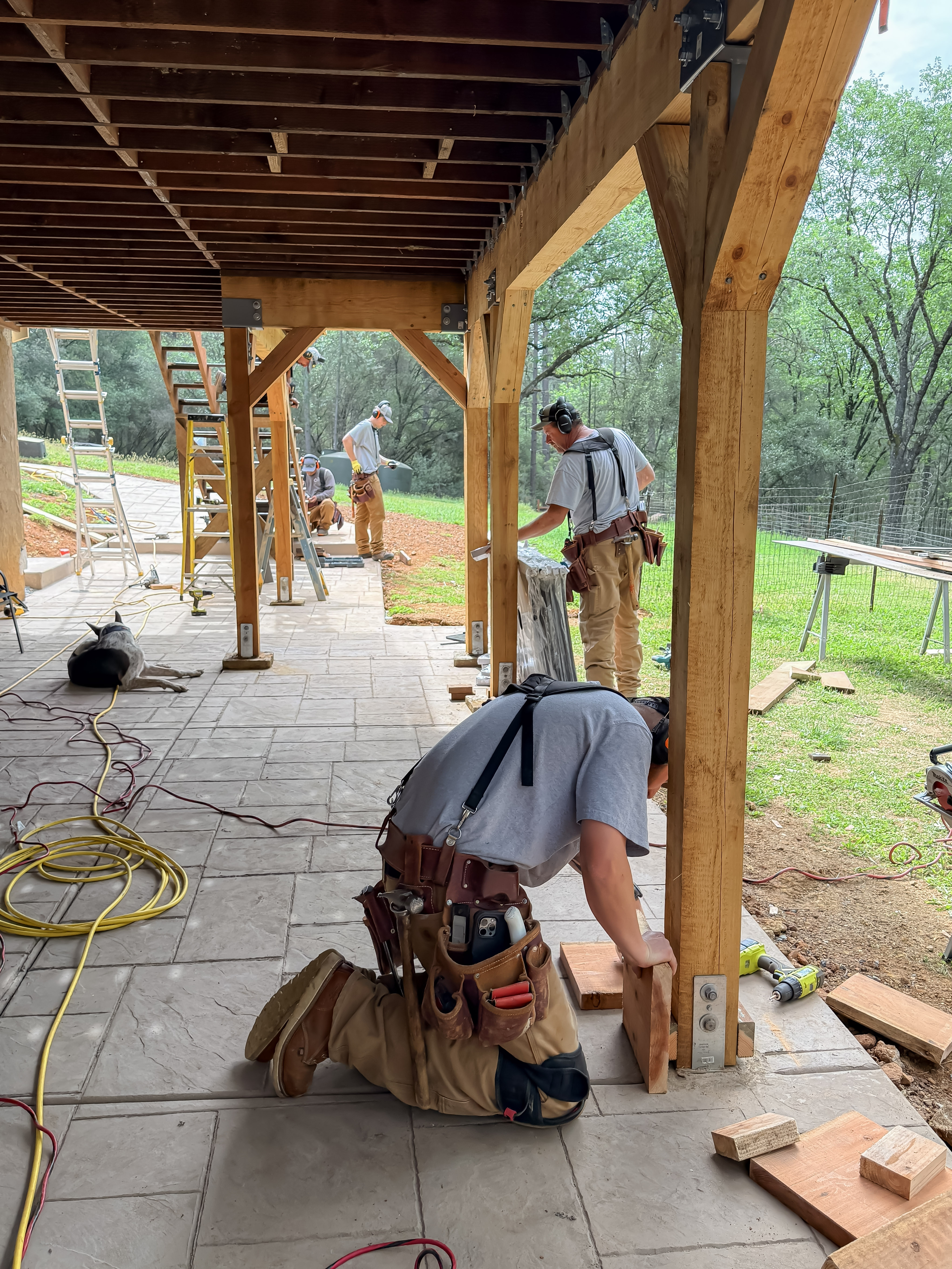 Crew setting timber frame posts under patio cover