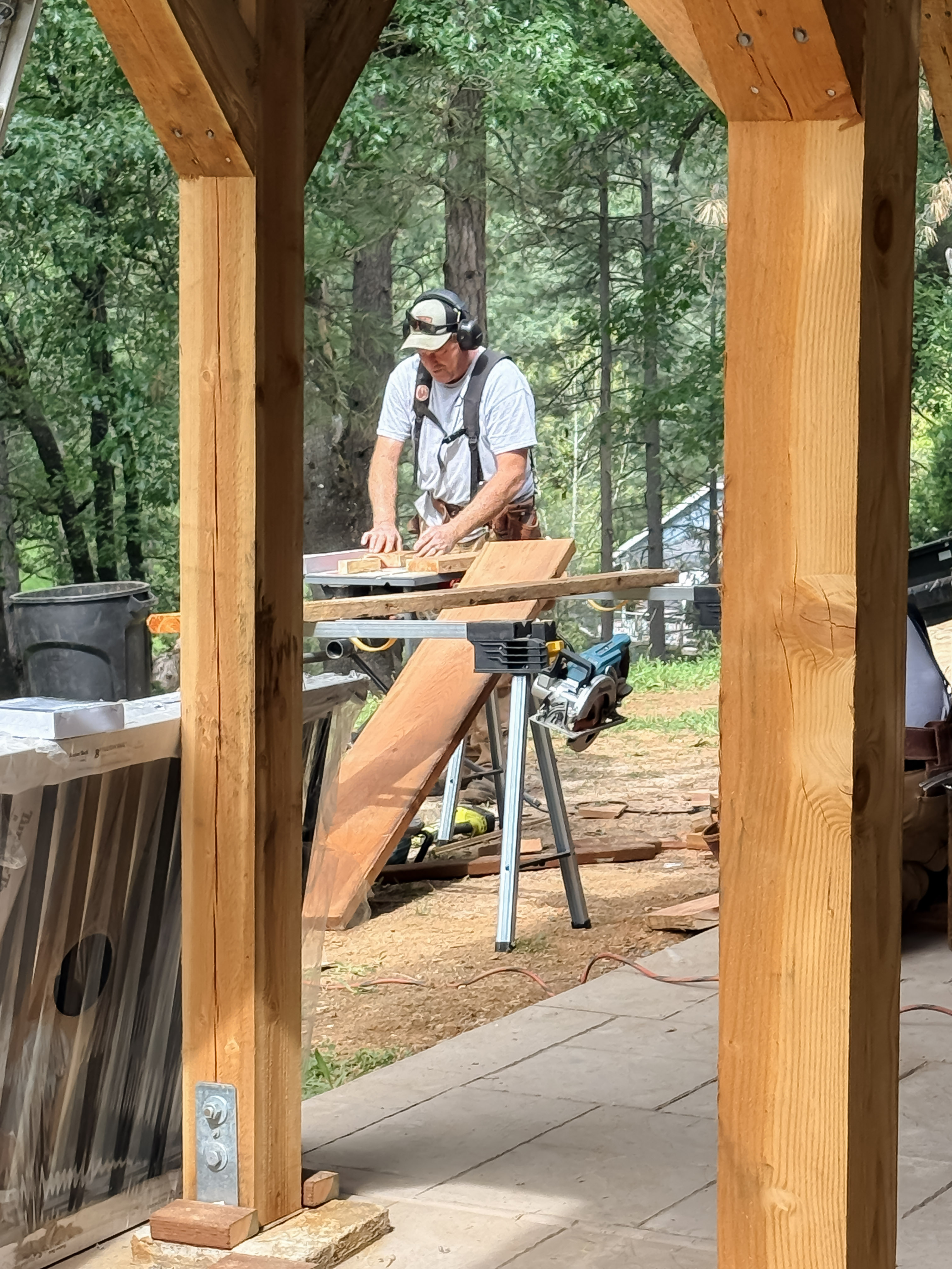 Worker framed by timber arch during patio cover build